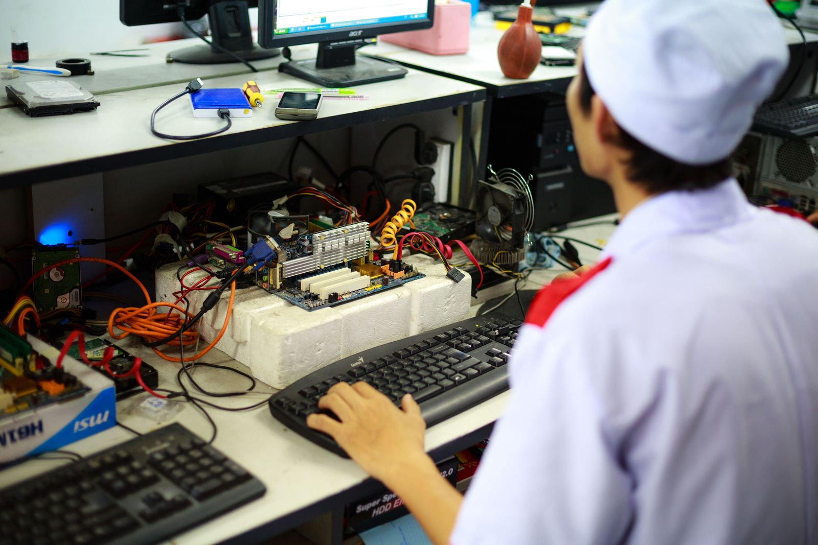 Engineer running test software with boards under test on the bench.