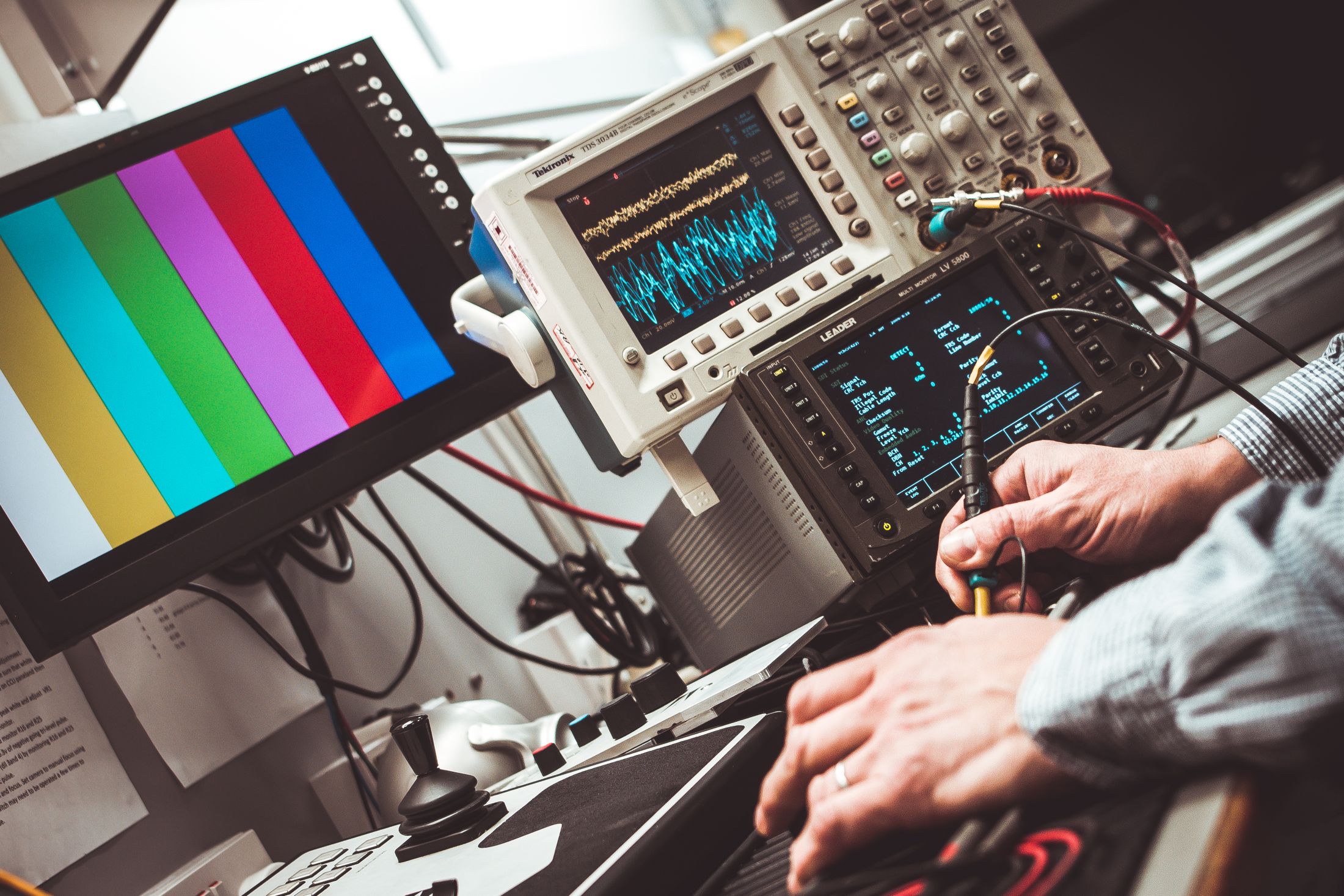 Technician working with oscilloscopes and electronic measurement instruments.