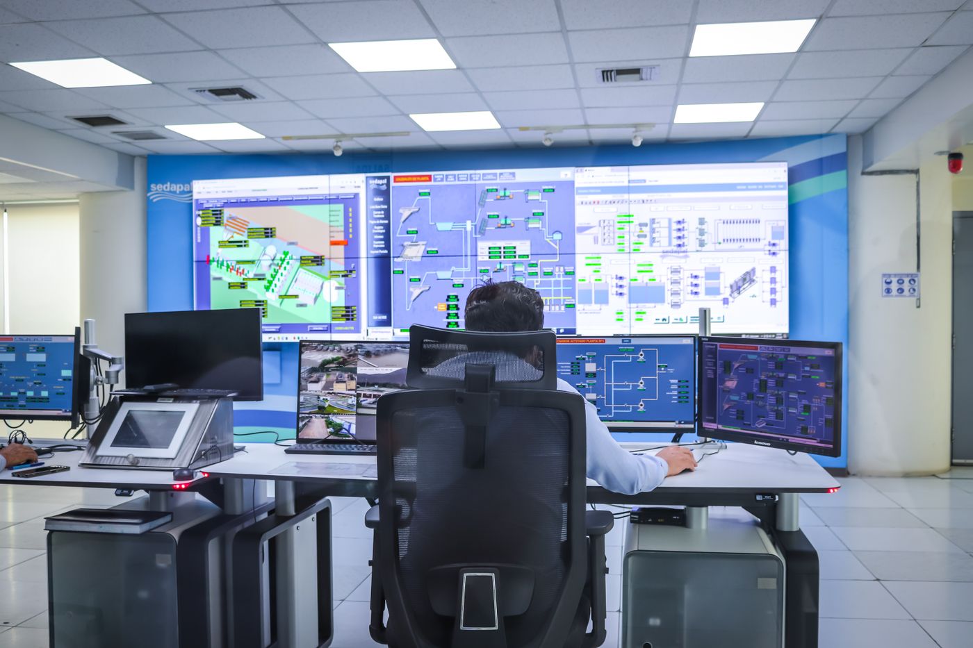 Operator reviewing production information on control room displays.