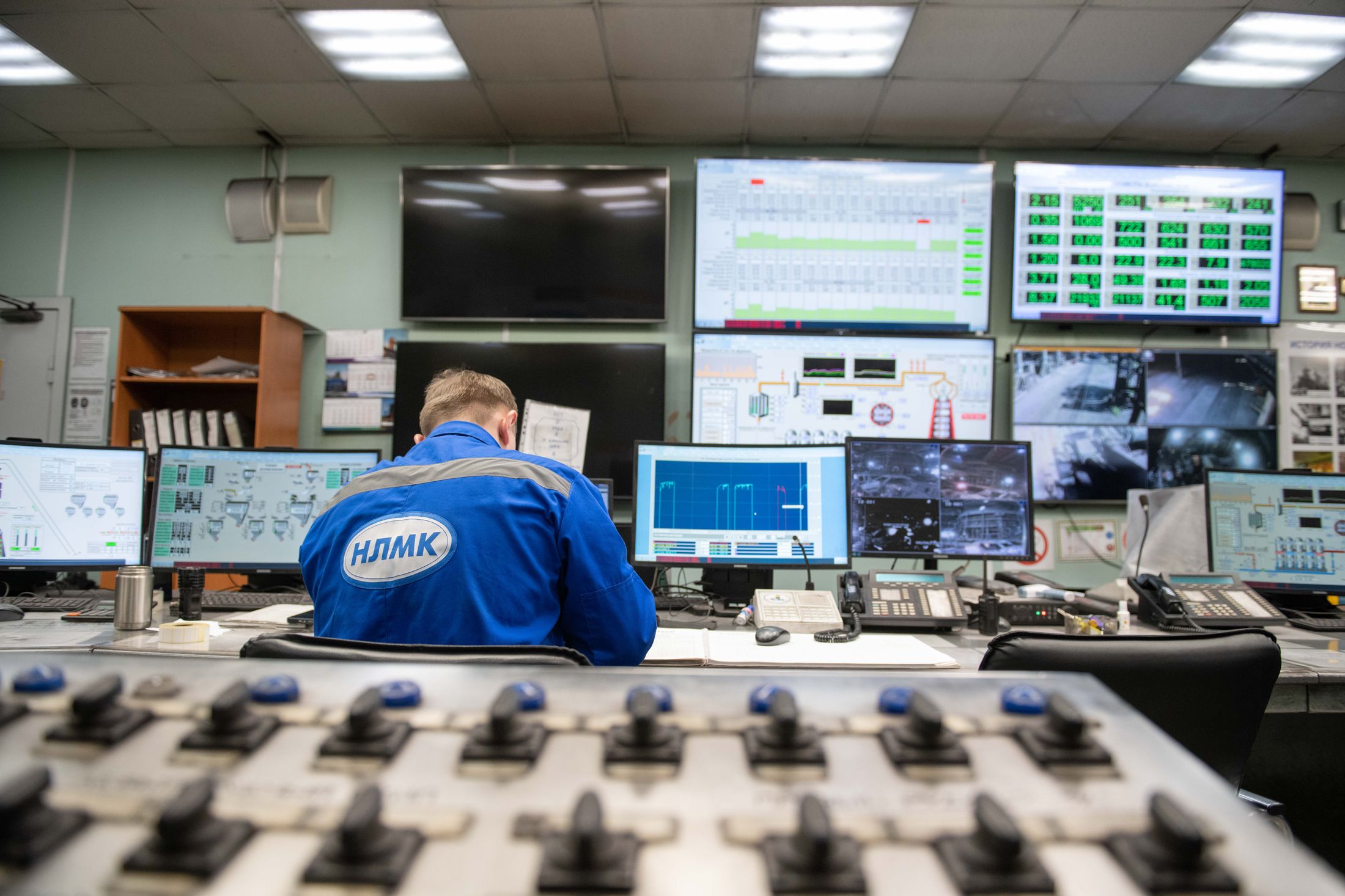 Plant operator monitoring process screens in an industrial control room.