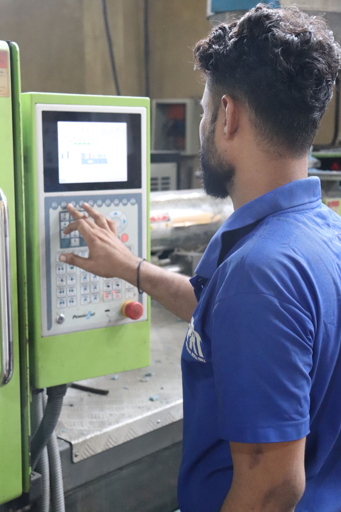 Production operator using the control panel of an industrial machine.