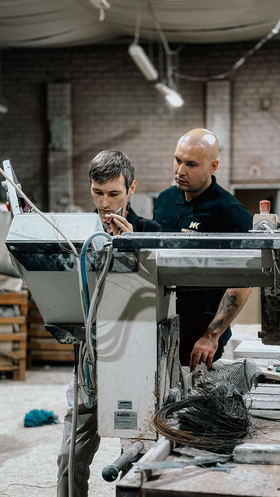 Small engineering team working together at a machine.