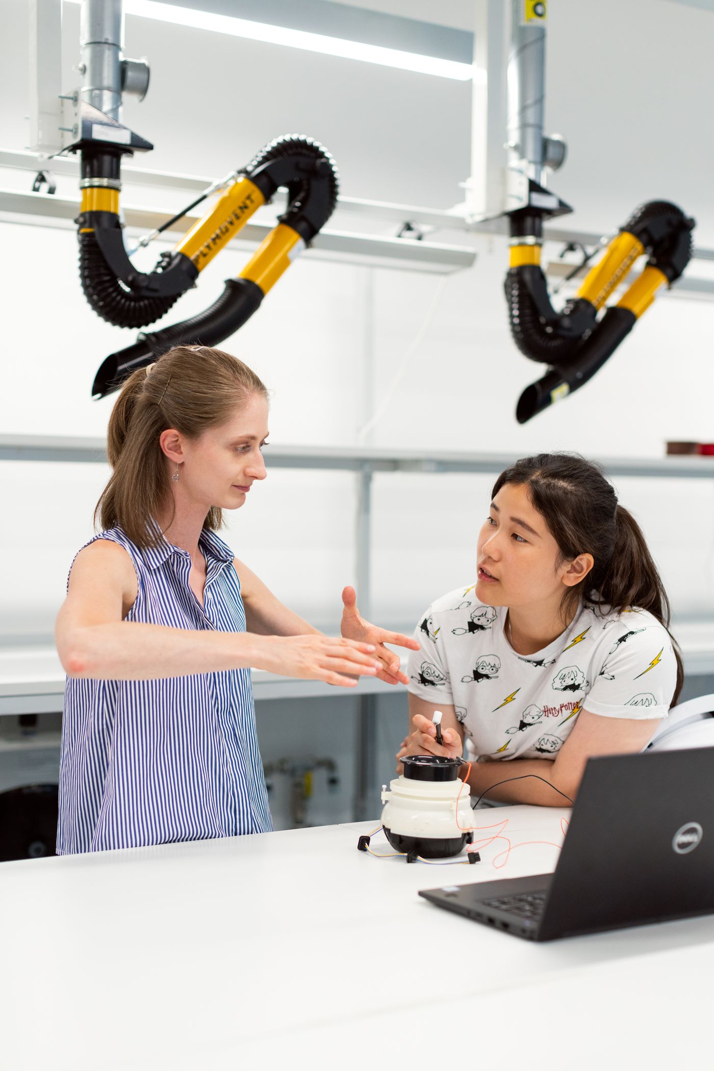 Two engineers developing a robotic system at a laboratory workbench.