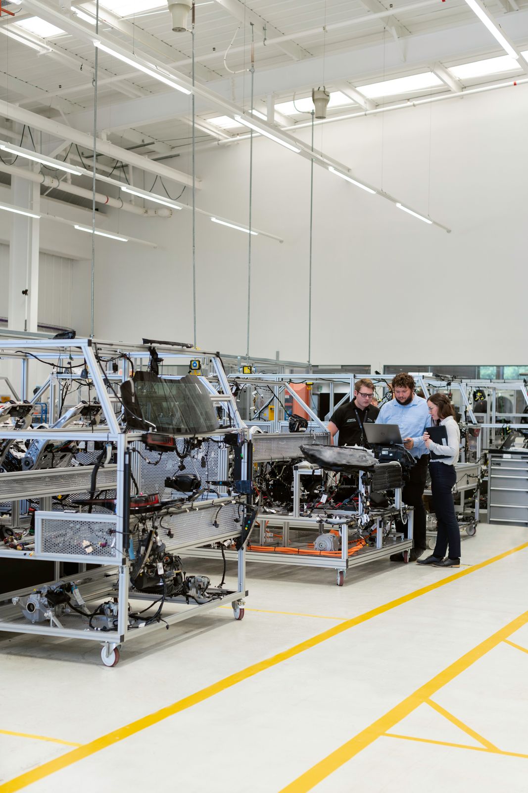 Engineers at a new production line in a bright facility.