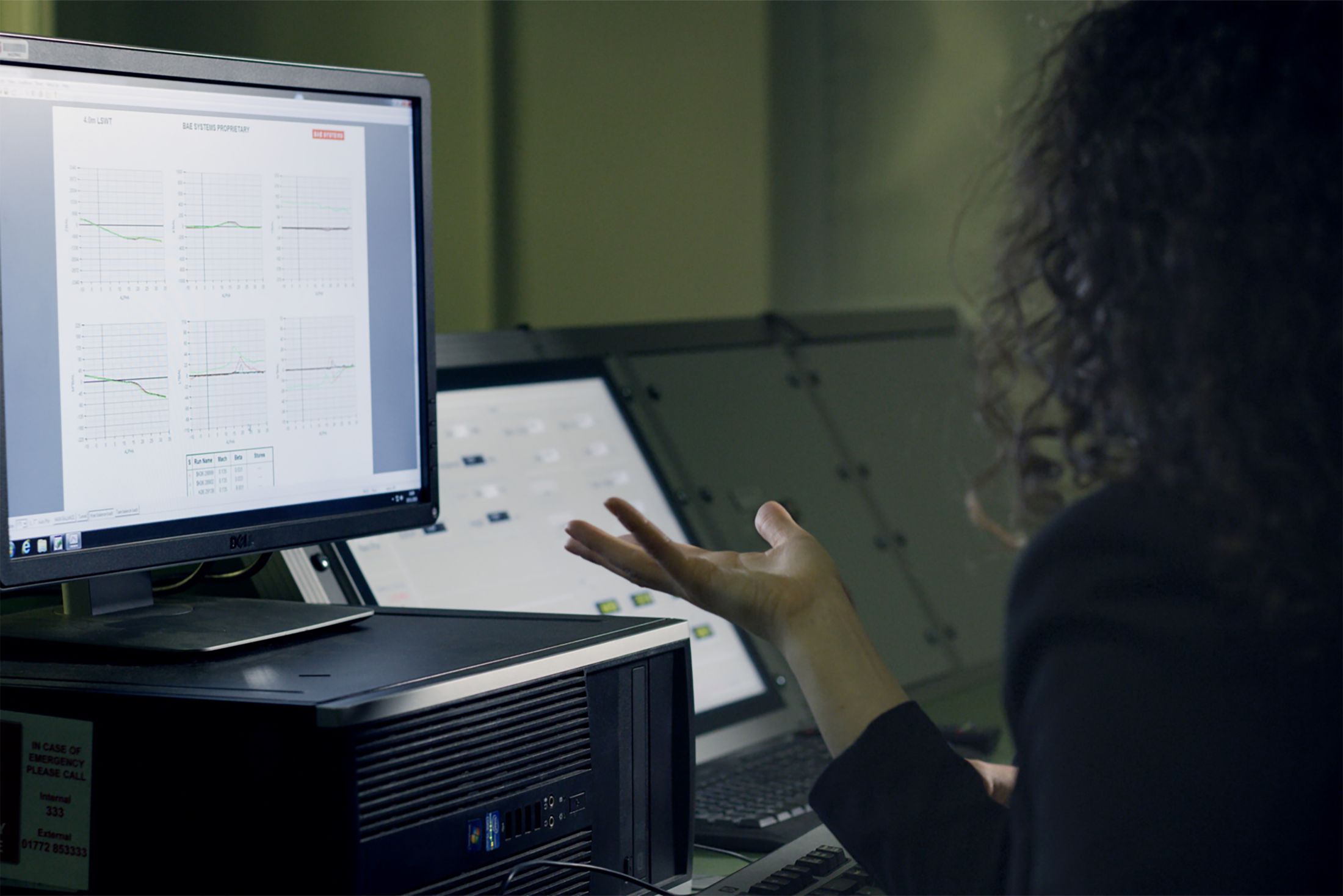 Engineer analysing technical data at a computer workstation.