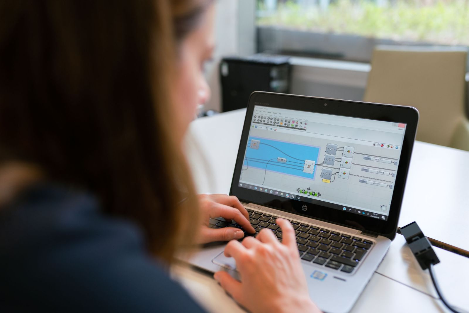 Engineer building a process logic model on a laptop.