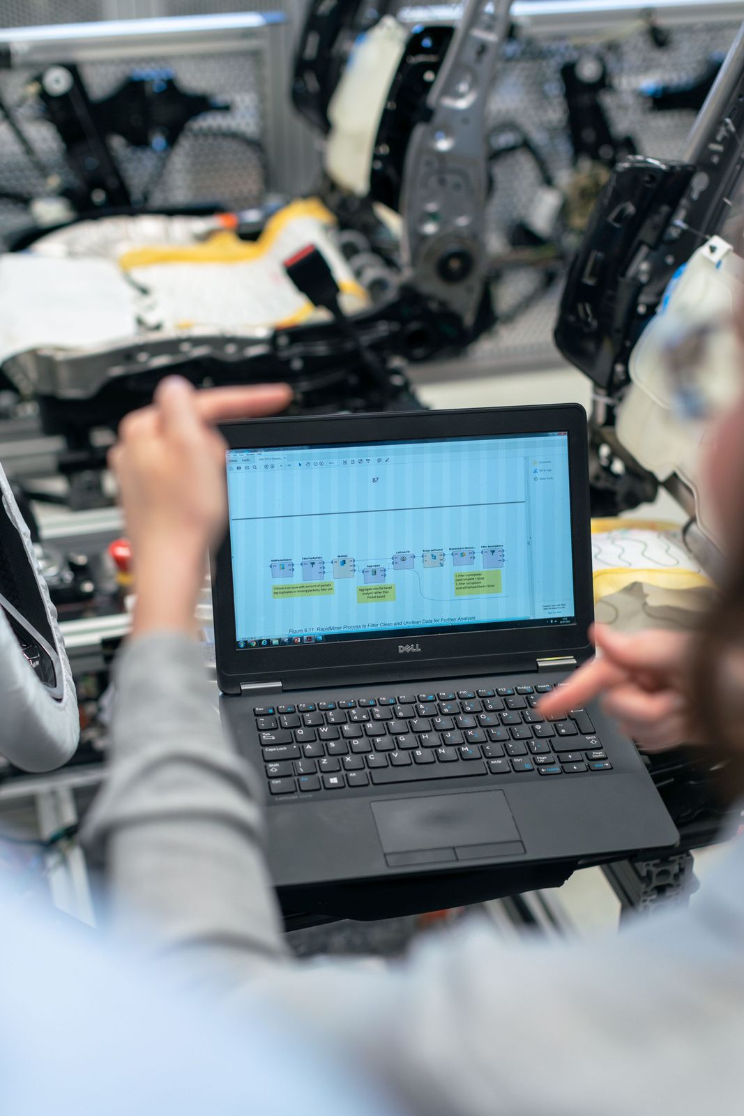 Engineer checking live test data on a laptop inside a test cell.