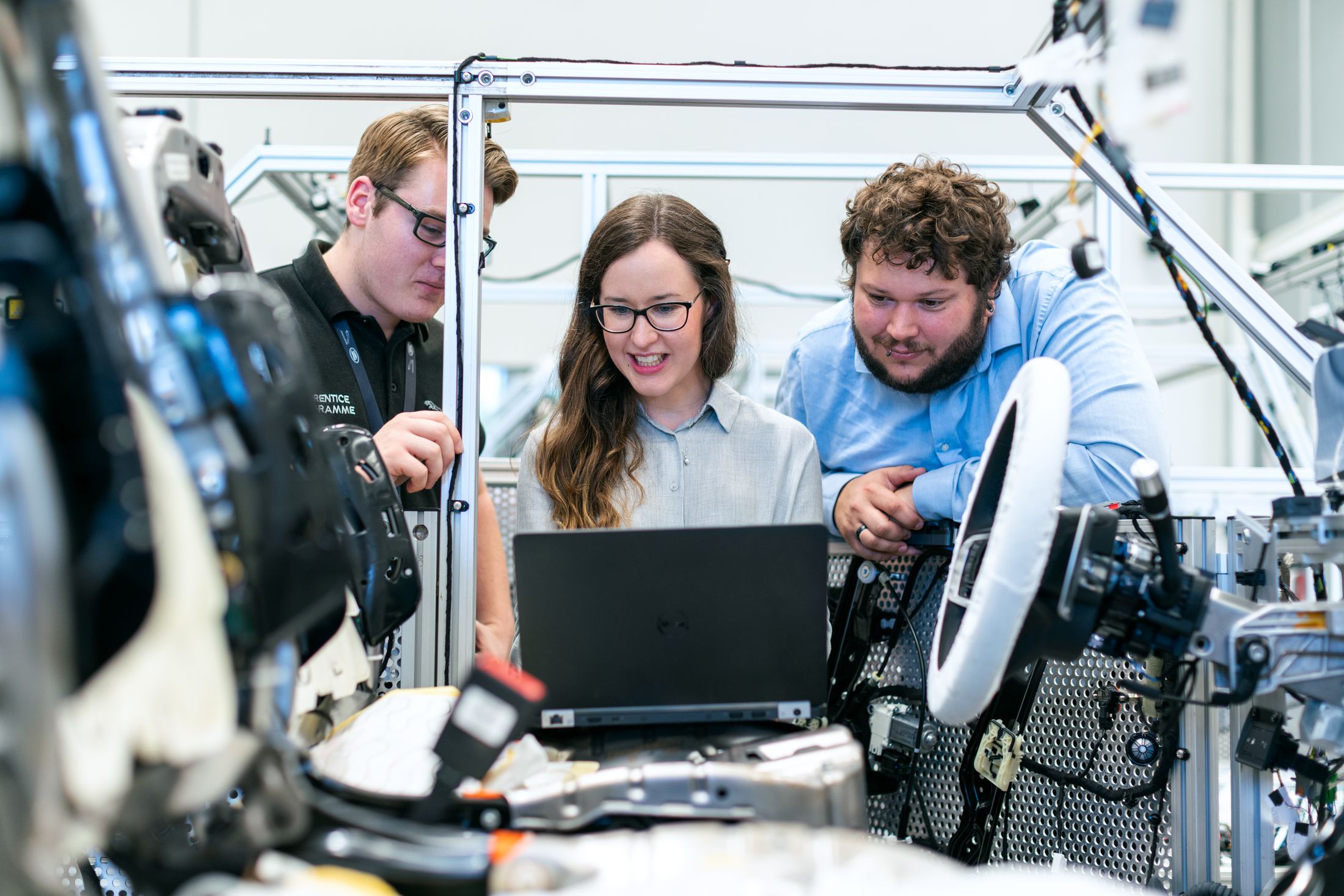 Engineers reviewing equipment together in an automotive workshop.