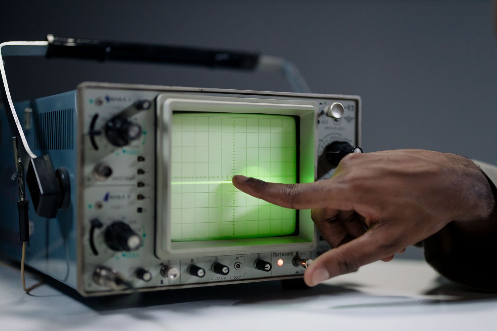 Engineer pointing at a signal on an oscilloscope.