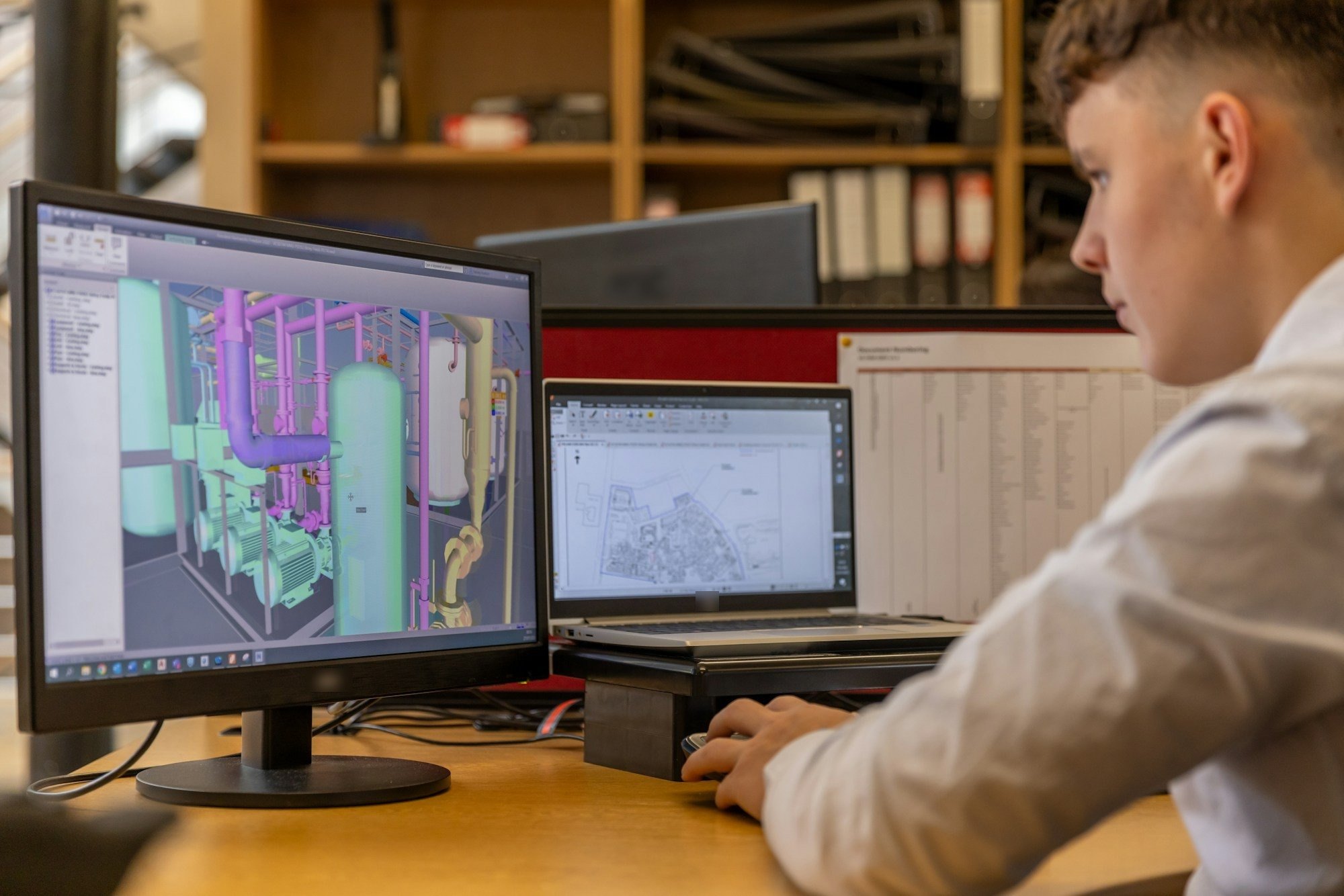 Engineer reviewing a 3D plant model on a monitor before changes on the shop floor.