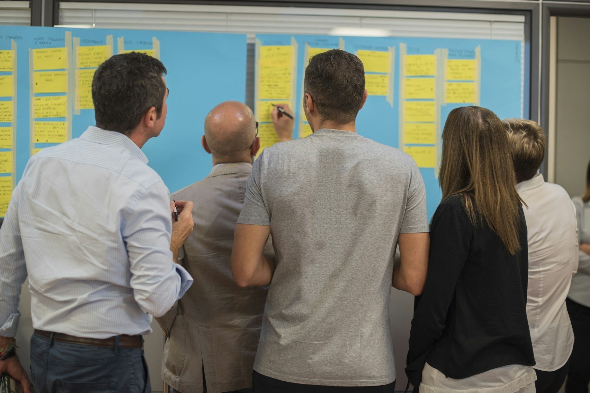 Team mapping improvement ideas on a sticky-note board.